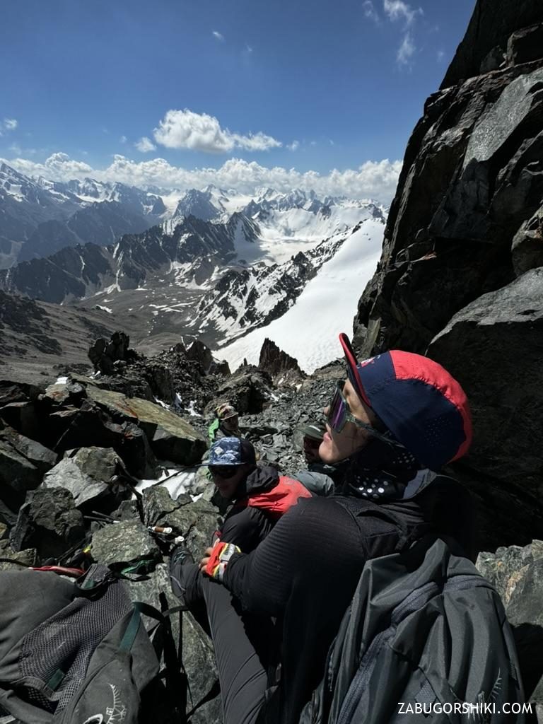 Climber on the rocks just below the summit of Peak Adygene